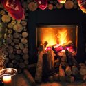 Cheminée en feu avec des chaussettes de Noël pendues et des bougies à côté