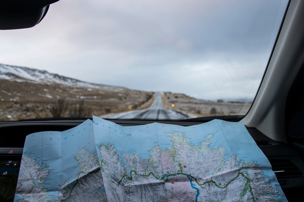 Une carte dépliée à l'avant d'une voiture sur une route déserte